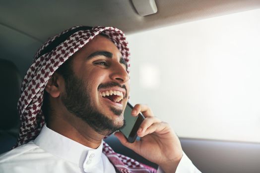 The successful keep moving. a young muslim businessman using his phone while traveling in a car.