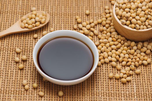Soy sauce and soy bean on wooden table