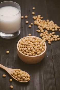 Glass with soy milk and soy bean on wooden background