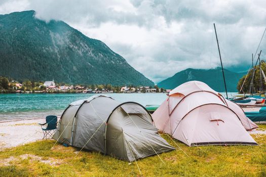 Camping tents on the coast of the alpine lake in Bavaria, Germany. Outdoor vacation in mountains