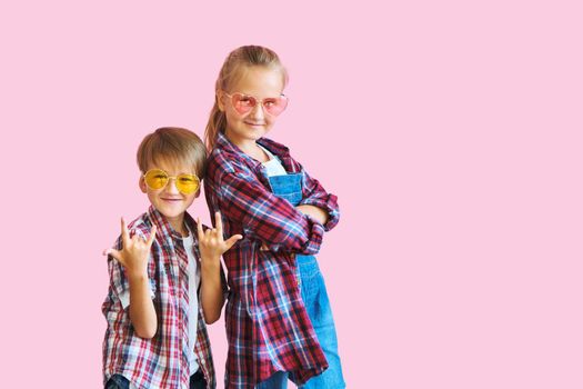 Cute stylish kids in color sunglasses looking at camera a