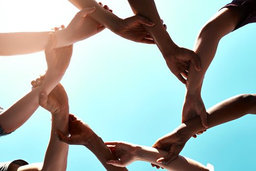 Unity is the most powerful weapon. a group of unidentifiable businesspeople joining their hands in a gesture of unity.