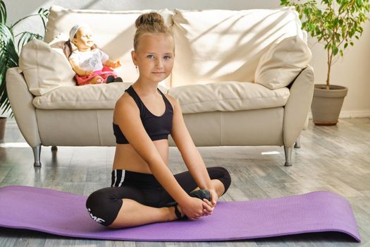 Kid repeating exercises while watching online yoga gymnastics session