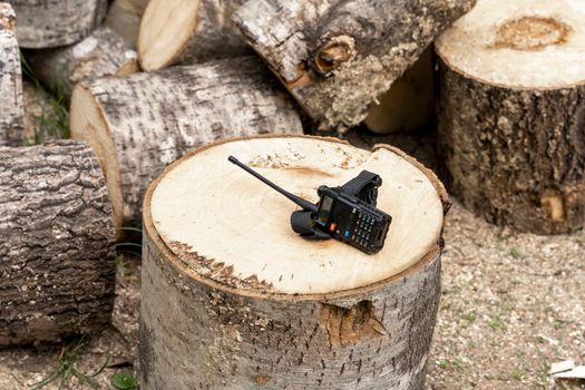 the walkie-talkie is lying on a wooden stump. Means of communication. radio communication. High quality photo