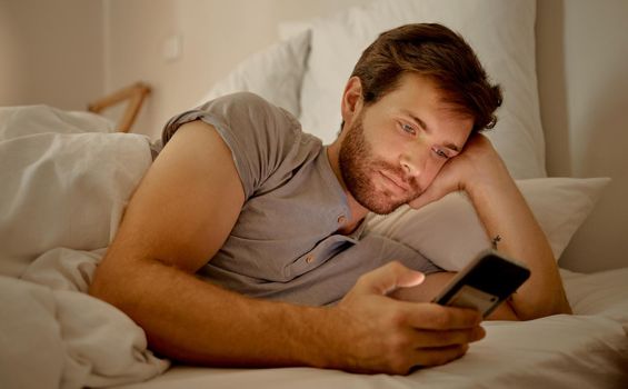 Insomnia, bored and social media in bed to destress and calm. Sleeping problems, anxiety and depression or smartphone addiction. Mental health issues or cheating online with mobile app.