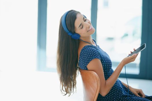 The weekend playlist. an attractive young woman listening to music.