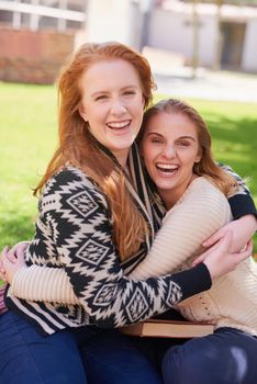 Forging life long friendships at college. two happy friends hugging outdoors.