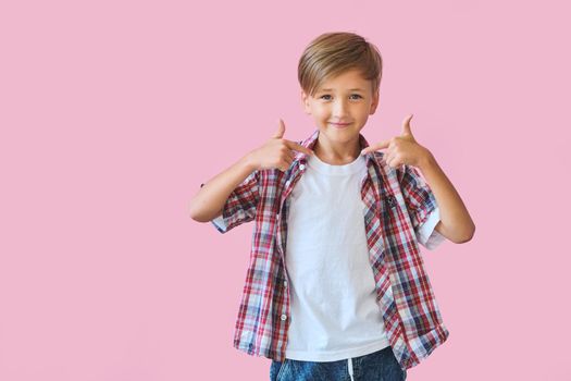 Young happy teen boy with in casuals on pink background.