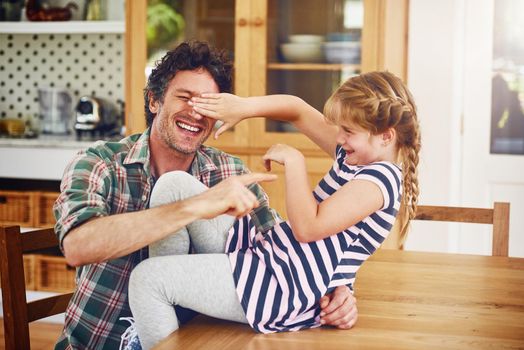 No day goes by without sharing laughter between them. a father and his little daughter having fun together at home.