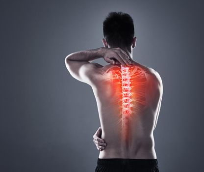 Back injuries are no joke. Rearview shot of a young man in the studio with cgi highlighting his back injury.
