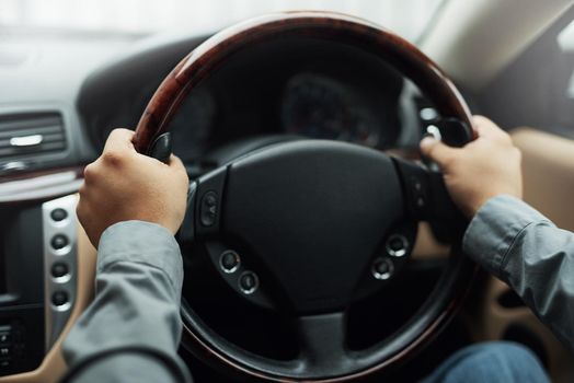 Hands on the wheel. hands holding onto a steering wheel while driving.