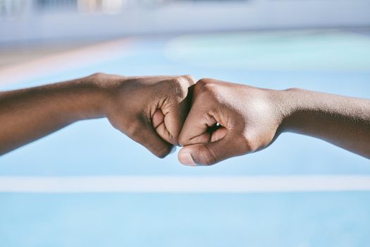 Closeup of hands, fist bump and the teamwork of two athletic, sporty, and active male athletes. Team of black people, friends or teammates working together showing respect, collaboration and support.