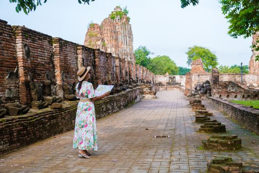 Ayutthaya, Thailand at Wat Mahathat, women with a hat and tourist map visiting Ayyuthaya Thailand