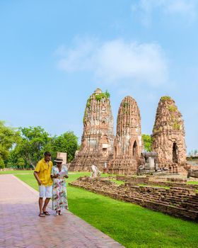 Ayutthaya, Thailand at Wat Mahathat, couple men and women with a hat and tourist map visiting Ayyuthaya Thailand
