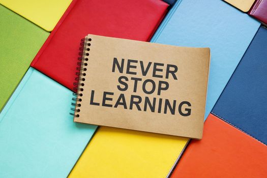 Never stop learning sign on the colorful books.
