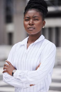 Motivation, vision and mission with a mindset of vision and a mission of growth and development for her company in the city. Portrait of a business woman standing arms crossed on an urban background