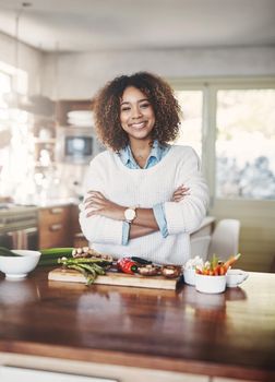 Wellness, cooking and a healthy lifestyle at home with a happy woman starting a weight loss journey. Portrait of a female smiling preparing a nutritious meal with organic vegetables in a kitchen