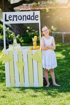 Ready for business. Portrait of a little girl selling lemonade from her stand outside.