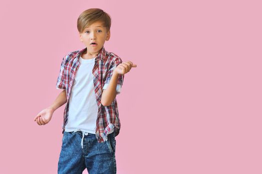 Young happy teen boy with in casuals on pink background.