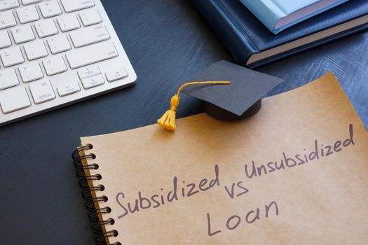 Sign Subsidized vs unsubsidized student loan and graduation cap.