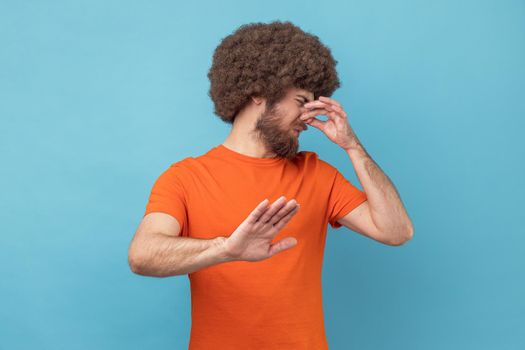 Man turning away and nose in disgust, avoiding unpleasant smell of farting, stop gesture.