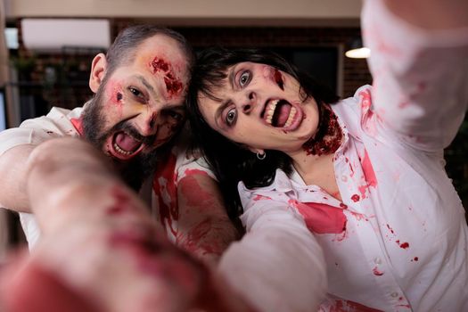 Portrait of scary zombies couple in office