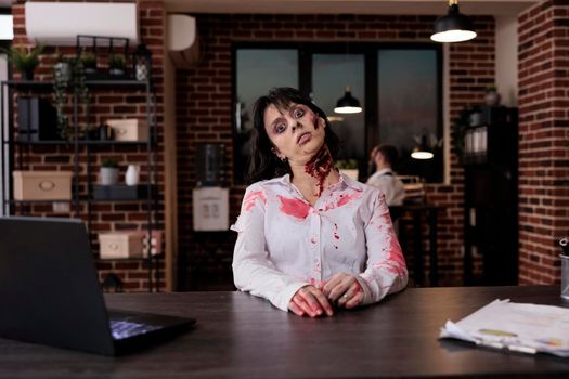 Portrait of creepy woman zombie at desk