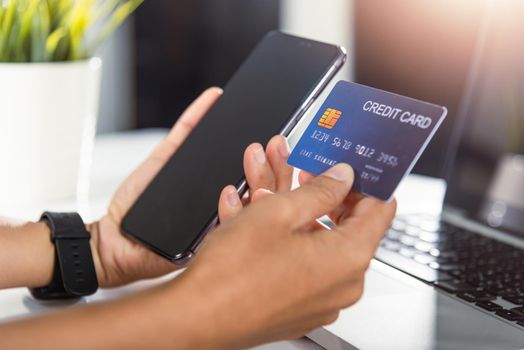 Woman hands holding credit card and smartphone with product purchase at home