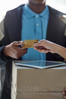 Shopping made smart. a customer using a credit card to pay for a delivery made by a courier.