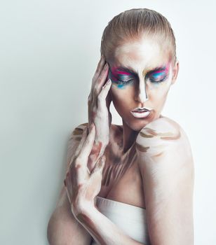 Strange and mysterious. Studio shot of a young woman posing with paint on her face.