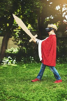 En garde. a little boy in a kings costume playing with a vr headset on.