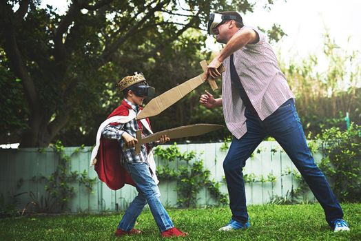 Virtual reality is a real boredom buster. a little boy and his father playing together outside while wearing vr headsets.