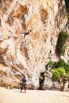 They share an adventurous spirit. two young people rock climbing on a sunny day.