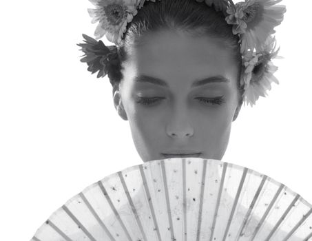 Grey cant kill the summer beauty. Black and white shot of a beautiful young woman wearing a crown of flowers while holding a fan in front of her face.