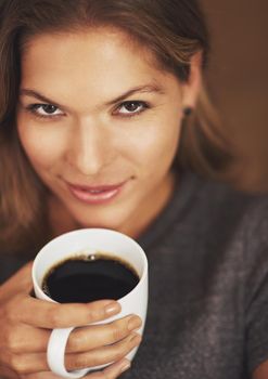 My coffee and I are having a moment. Portrait of a young woman enjoying a cup of coffee at home.