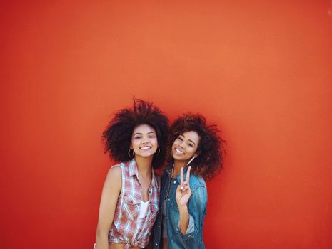 Bestieswere like two of a kind. two young friends posing against a red background.