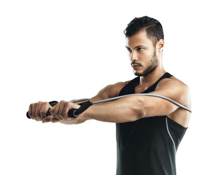 Strengthening his body with resistance training. Studio shot of a young man working out with a resistance band against a white background.