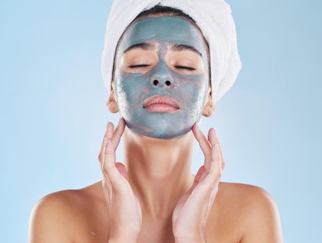 Skincare, beauty and face mask on a woman while doing her wellness routine in a studio. Latina girl with fresh, body care and hygiene lifestyle doing selfcare facial treatment to relax after a shower