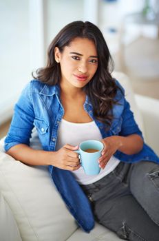 Start your weekend with a fresh cup. a young woman drinking coffee while relaxing at home.