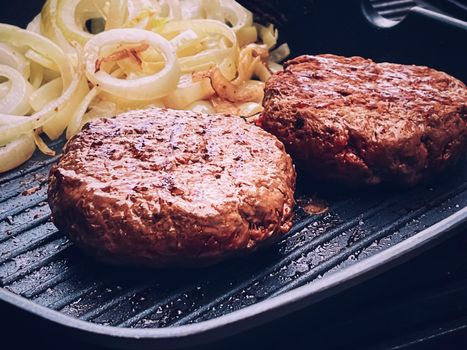 Cooking minced beef burger on cast iron grill skillet outdoors, red meat on frying pan, grilling food in the garden, English countryside living