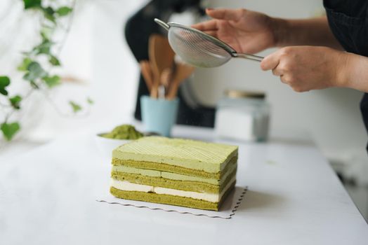 Pour green tea powder over delicious cheesecake