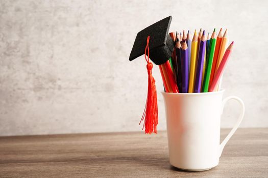 Graduation hat with colorful pencils on book with copy space, learning university education concept.