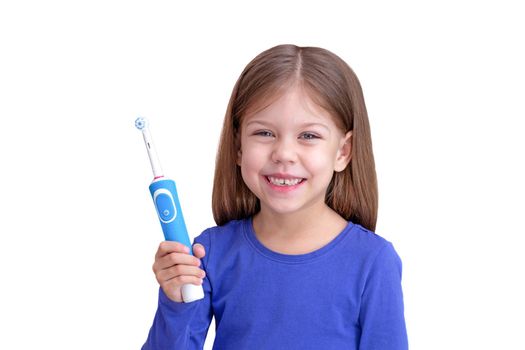 Smiling child holding electric toothbrush