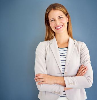 Happiness is the key to success. a woman dressed in office-wear posing against a blue background.