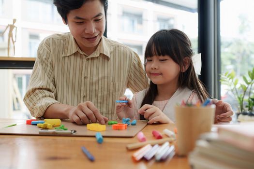 Adorable little girl and father playing with colorful plasticine. Handmade skills training