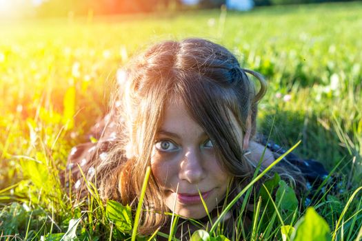face of a girl lying in the grass close-up. summer outdoor recreation