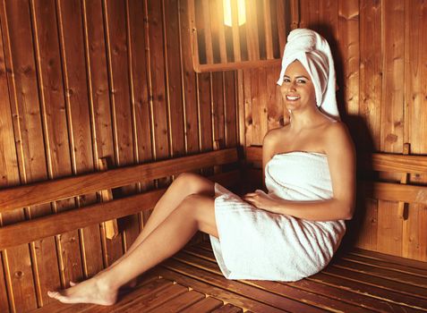 Enjoying a day of pampering. Full length portrait of a young woman relaxing in the sauna at a spa.