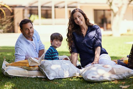 We love picnicking. a family enjoying a picnic together.