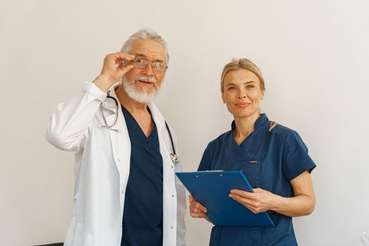 Two doctors colleague in uniform standing in medicine clinic and looking camera