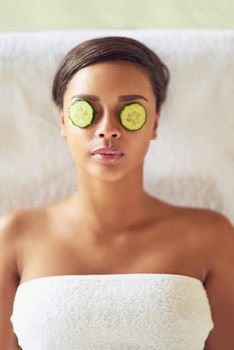 Everyone deserves a break, even your eyes do. a young woman with cucumber slices over her eyes receiving a beauty treatment at a spa.